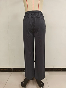 Detail of high waist elastic waistband and back lifting seams on dark gray sports pants