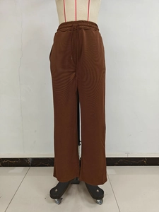 Close-up of drawstring elastic waistband on brown wide-leg trousers with ribbed texture