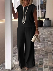 Detail of elegant black two-piece set featuring sleeveless top and high-waist trousers