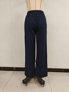 Detail view of navy blue wide-leg sports pants featuring elastic high waist and back seam