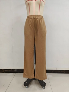 Detail of khaki wide-leg pants showing elastic waistband with adjustable drawstring