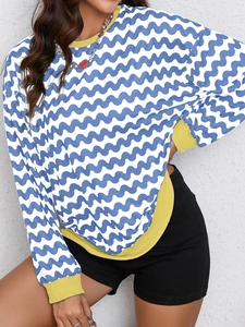 Detail of blue and white wave pattern sweatshirt with yellow ribbed collar and cuffs