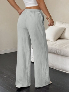Detalle de pantalón ancho gris claro mostrando tejido texturizado y cintura alta