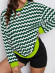 Detail of sweatshirt showing green wavy pattern and bright lime ribbed cuffs