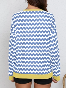 Detail view of wave pattern colorblock sweatshirt showing yellow ribbed hem and loose fit