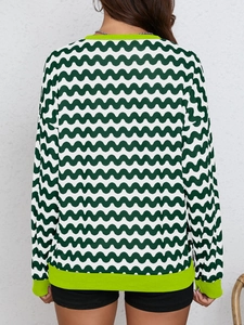 Detail of green wave pattern long sleeve sweatshirt with fluorescent ribbed cuffs
