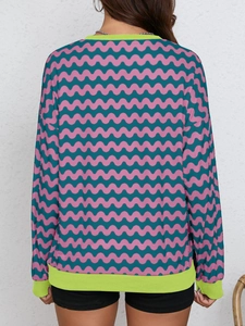 Detail of color-block wavy print sweatshirt with vibrant green ribbed cuffs and hem