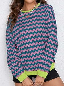 Detail of pink and green wavy pattern sweatshirt with neon ribbed collar and cuffs