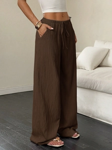 Detalle de los pantalones de pierna ancha marrón oscuro con cintura alta y bolsillos