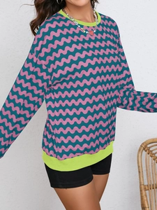 Detail of wave pattern sweatshirt showing vibrant green ribbed neck and pink colorblock style