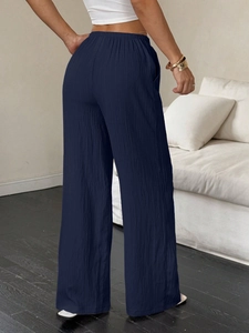 Detalle de los pantalones anchos azul marino con textura rugosa y corte de cintura alta