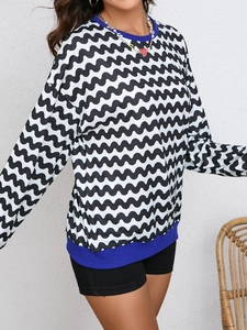 Detail of wave print sweatshirt with blue ribbed neckline and loose-fitting long sleeves
