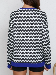 Detail view of wave pattern sweatshirt with blue ribbed cuffs on sleeve and hem