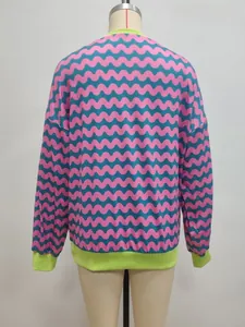 Detail of pink and teal wavy stripes on a sweatshirt with neon green ribbed cuffs