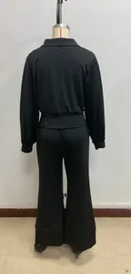 Detail view of the elastic high waist and draped black wide leg trousers of the set