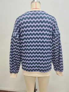 Detail view of wavy pattern sweatshirt featuring contrasting cream ribbed neck and cuffs
