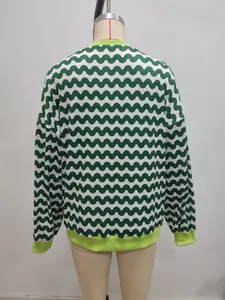 Detailed close-up of green and white wavy pattern sweatshirt with neon ribbed cuffs