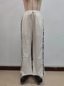 Detail der weißen weiten Hose mit Kordelzug und seitlichen Einsätzen mit Leopardenmuster