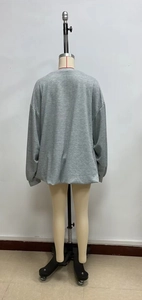 Detail of grey oversized sweatshirt showing soft jersey texture and ribbed sleeve cuffs