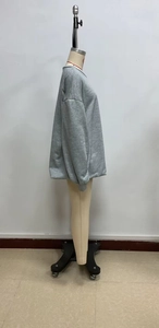 Detailed side view of grey long sleeve crewneck sweatshirt on a mannequin model