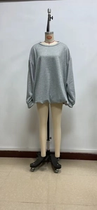 Detailed view of oversized grey crewneck sweatshirt with dropped shoulders on mannequin