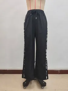Detail von Kordelzug am Bund und Leopardenmuster-Streifen an schwarzer weiten Hose