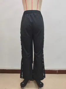 Detail der weiten Hose mit Kordelzug und Leopardenmuster-Seitenstreifen auf schwarzem Stoff