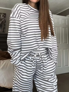 Close-up of gray and white striped lounge set with drawstring waist in a cozy bedroom