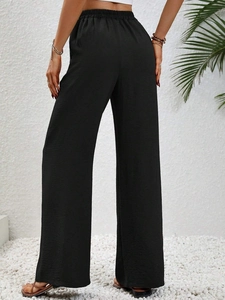 Dettaglio dei pantaloni neri a vita alta con elastico in vita e tessuto fluido elegante