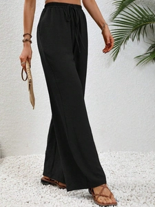 Dettaglio dei pantaloni a gamba larga a vita alta con coulisse elastica in tessuto nero