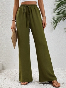 Close-up of olive green wide-leg trousers featuring elastic drawstring waist and side pockets