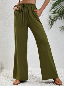 Detail of olive green wide-leg trousers with drawstring waist and breathable fabric