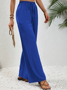 Macro shot of blue wide-leg trousers showing the elastic drawstring waist and ribbed texture