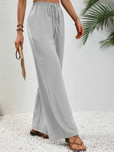 Detail of light gray high-waisted wide-leg trousers with elastic waistband and drawstring
