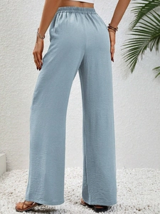 Macro detail of light blue high waist wide leg trousers in crinkle fabric texture