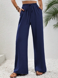 Dettaglio dei pantaloni larghi blu scuro con elastico in vita e coulisse regolabile