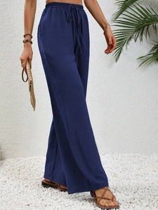 Dettaglio dei pantaloni blu navy a vita alta con coulisse e tessuto dalla trama increspata