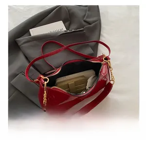 Detailed interior capacity showing red glossy bag with gold chain and large storage space