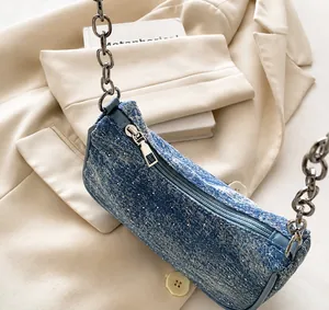Nahaufnahme von glattem Metallreißverschluss und Denim-Textur auf Strass-Tasche
