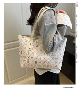 Detail of printed tote bag with cartoon bears and bows shown from a side-view on shoulder