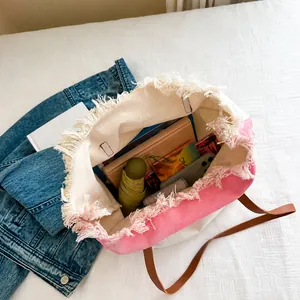 Detail van de ruime binnenkant van de roze en witte canvas tas met franjes