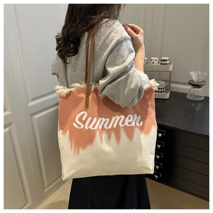 Detail van canvas tas met kleurverloop, franjes, Summer-print en lederen schouderband