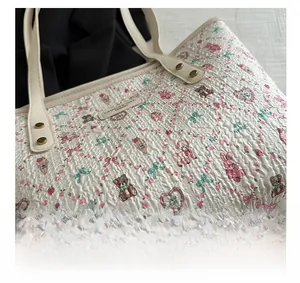Close-up of quilted tote bag featuring cute cartoon prints and metal rivet details