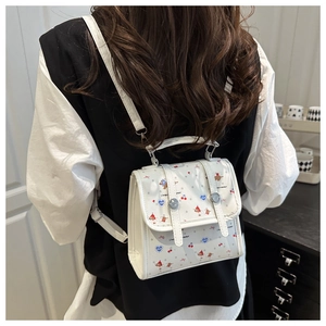 Model trägt einen weißen Mini-Rucksack mit niedlichen Welpen- und Kirschmotiven