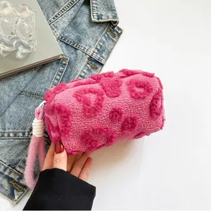 Macro detail of plush pink vanity bag with fuzzy heart texture and zip closure