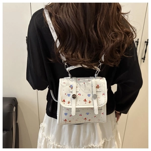 Detailansicht Mini-Rucksack in Weiß mit Kirsch- und Hundeprint sowie Metallschnallen