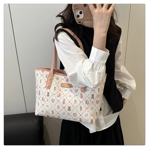 Close-up of pink leather straps and cartoon bear print on the white tote bag detail