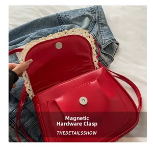 Close-up of the red lace-trimmed crossbody bag showing the magnetic hardware buckle