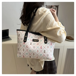 Detail of printed tote bag featuring cute bears and hearts with sleek black straps
