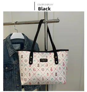 Detailed view of white cartoon printed tote bag featuring logo plaque and black straps